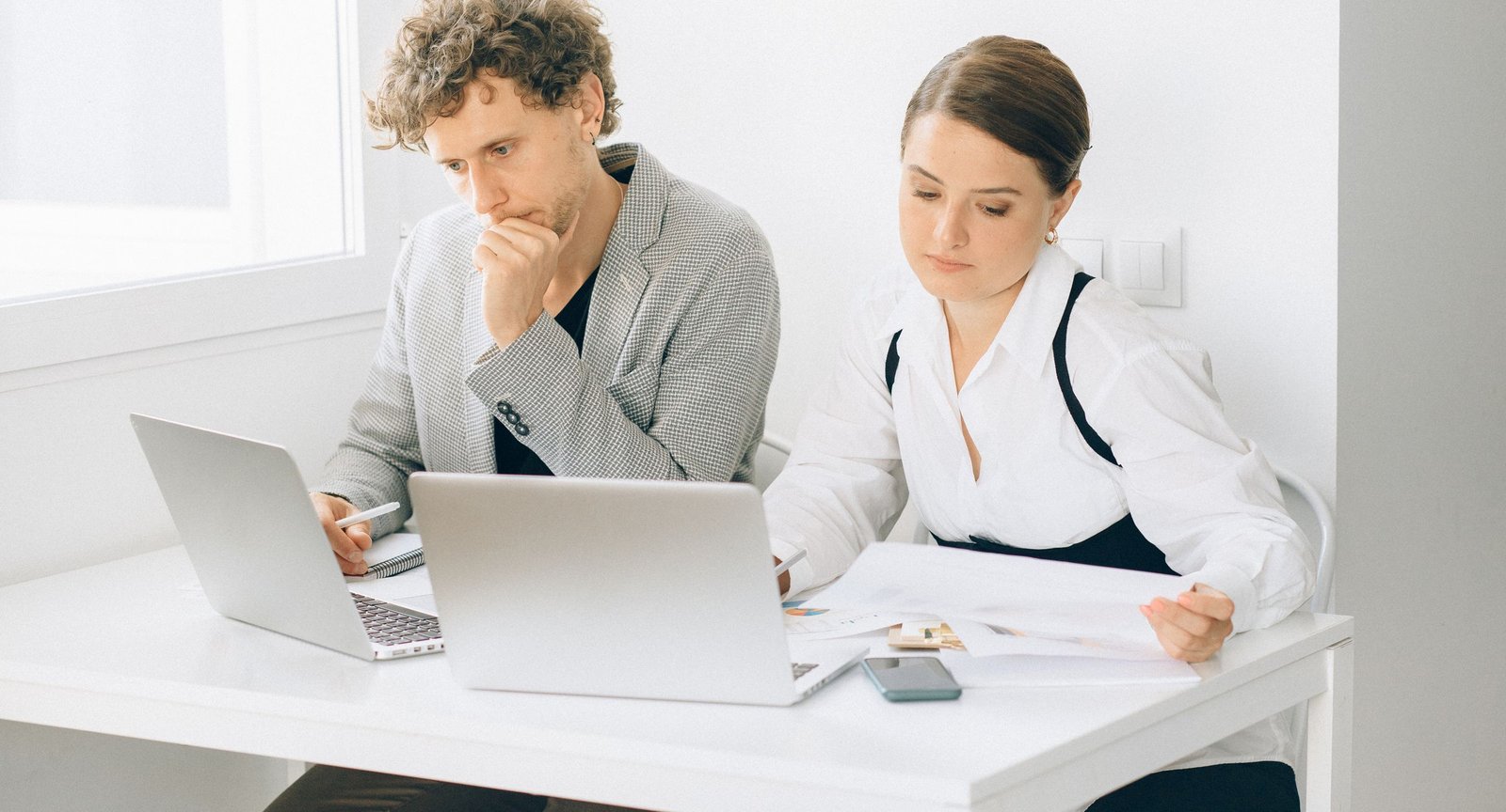 Business consultants reviewing plans on laptops